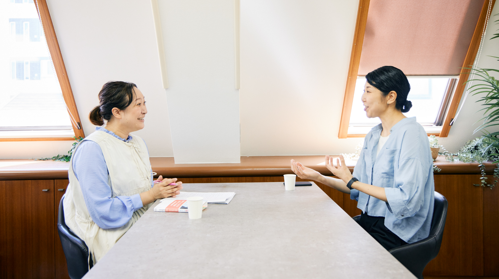 テーブルを挟んで向かい合う川島さんと田中さん